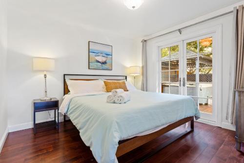 @ Marbella Lane - 3BR Belmont Cozy House في بلمونت: غرفة نوم مع سرير مع اثنين من الحيوانات المحشوة عليه