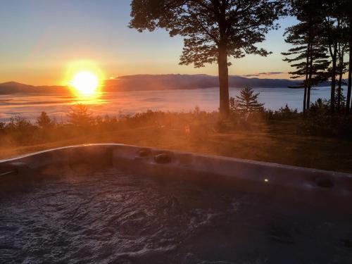 a hot tub with the sunset in the background at RL Breathtaking views and grand unique style private mountain retreat 4WD recommended in Whitefield