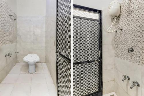 La salle de bains est pourvue d'une douche et de toilettes. dans l'établissement Neelkanth Homes, à Garudeshwar