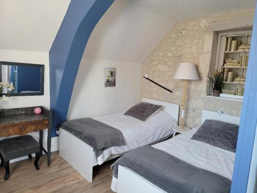 um quarto com 2 camas, uma secretária e uma janela em Gîtes et Chambres des Coteaux em Sainte-Maure-de-Touraine