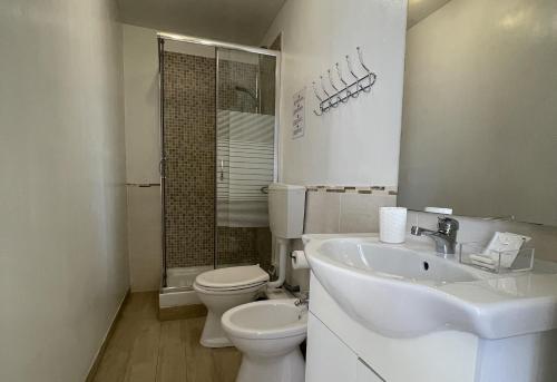 a white bathroom with a toilet and a sink at CconfortHotels Dolci Notti in Bari