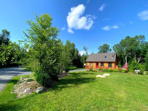 a large yard with a house and a tree at BC Log cabin with private beach river fire pit AC wifi onsite trails ski slope views in Carroll