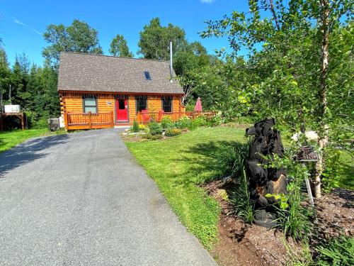 a log cabin with a driveway leading to it at BC Log cabin with private beach river fire pit AC wifi onsite trails ski slope views in Carroll