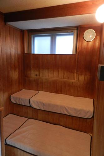 a small cabin with two bunk beds in it at Check In Matsuyama in Matsuyama