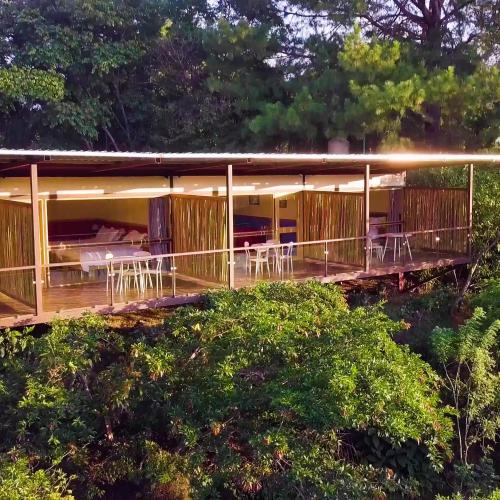 una casa con terraza con mesas y sillas en Hotel Pibi Boreal, en Alajuela
