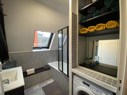 La salle de bains est pourvue d'un lave-linge et d'un lavabo. dans l'établissement Le KT-Dral - Appartement hypercentre, à Bourges