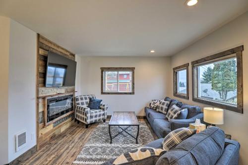 a living room with blue couches and a tv at Newly Built Bigfork Gem about 1 Mi to Fish and Hike in Bigfork