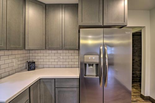 a stainless steel refrigerator in a kitchen with wooden cabinets at Newly Built Bigfork Gem about 1 Mi to Fish and Hike in Bigfork
