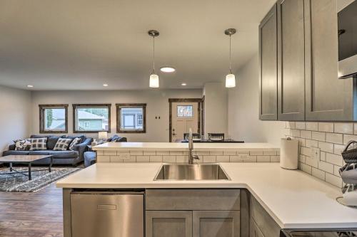 a kitchen with a sink and a living room at Newly Built Bigfork Gem about 1 Mi to Fish and Hike in Bigfork