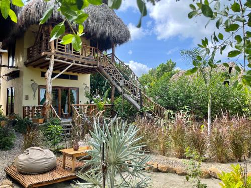 a house with a thatched roof with a wooden deck at Eco Xata in Santa Veronica