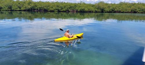 a man in a yellow kayak in the water at The Sunsetter Bed & Breakfast in Bocas del Toro