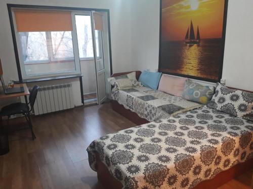 ein Schlafzimmer mit einem Bett, einem Sofa und Fenstern in der Unterkunft Apartments on Koktem 1 in Almaty