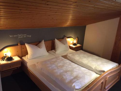 two beds in a room with two lamps on them at Staller Hof in Ruhpolding