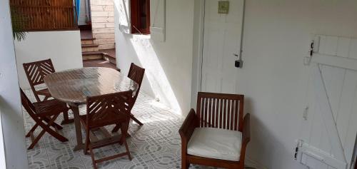 a dining room with a table and chairs and a door at La plage de Petit-Havre in Le Gosier