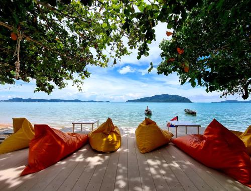 a group of pillows sitting on a wooden table near the water at Phuket Signature Glamping in Rawai Beach
