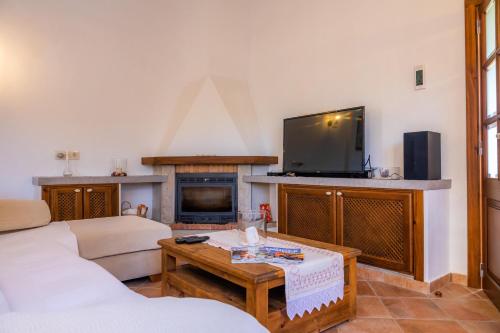 a living room with a couch and a tv at Villa Toni i María in Capdepera