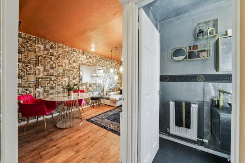 un soggiorno con tavolo in una camera con parete di The Medway Executive Apartment a Gillingham