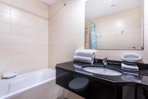 ein Badezimmer mit einem Waschbecken und einer Badewanne in der Unterkunft Live spacious 3BR apartment all En Suite & Balcony in Dubai