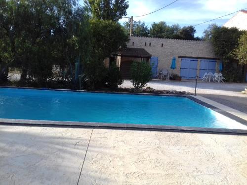 a large blue swimming pool next to a house at Mas de l'Olivier in Saint-Estève
