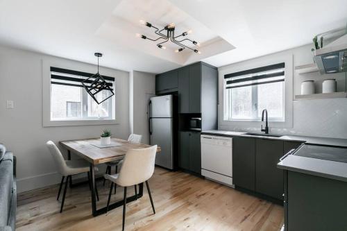 a kitchen with a table and chairs and a refrigerator at Complexe LIVTremblant by Gestion ELITE - LIV2 in Mont-Tremblant