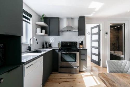 a kitchen with black and white cabinets and an oven at Complexe LIVTremblant by Gestion ELITE - LIV2 in Mont-Tremblant