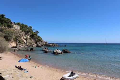 a beach with people and a boat on the beach at ASSINI View in Asíni
