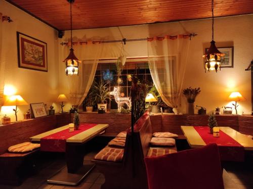 a restaurant with tables and chairs and a window at Hotel Pension Waldhof in Simmern