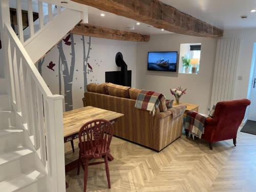 a living room with a couch and a table at The Good Life Wales with Hot tubs in Llywel