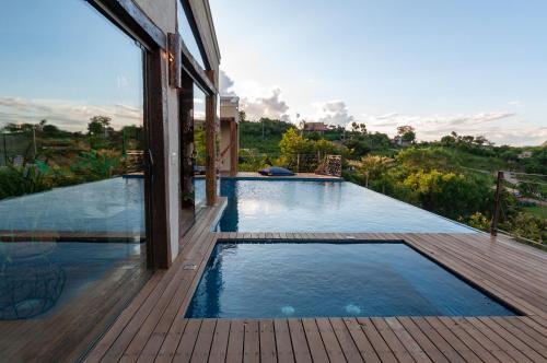 a swimming pool on a wooden deck next to a house at Sitio Jatoba/Lapinha da Serra in Santana do Riacho