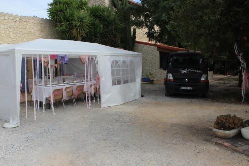 a white tent with a table in front of a car at Mas de l'Olivier in Saint-Estève