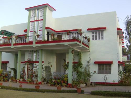a white building with a balcony on top of it at Jheelam Homestay in Bhopal