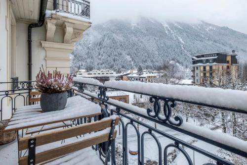 un balcon avec des bancs enneigés et une vue sur une ville dans l'établissement Nice Apt With Balcony In Chamomix, à Chamonix-Mont-Blanc