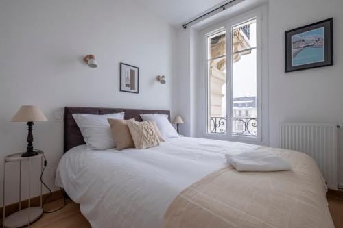 une chambre avec un grand lit blanc avec une fenêtre dans l'établissement Nice Apt With Balcony In Chamomix, à Chamonix-Mont-Blanc