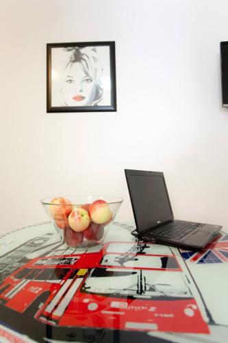 a table with a laptop and a bowl of apples on it at Apartments Top Center in Zagreb