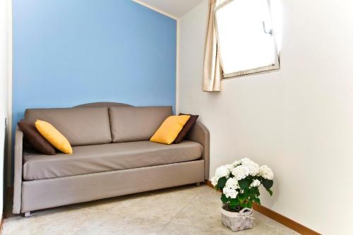 a living room with a brown couch with yellow pillows at Hotel Belvedere in Manerba del Garda