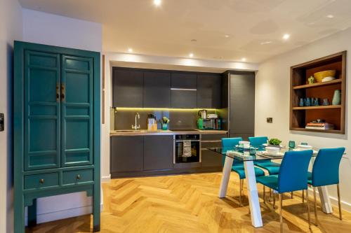 a kitchen with a dining table and blue chairs at Twenty Seven HQ in York