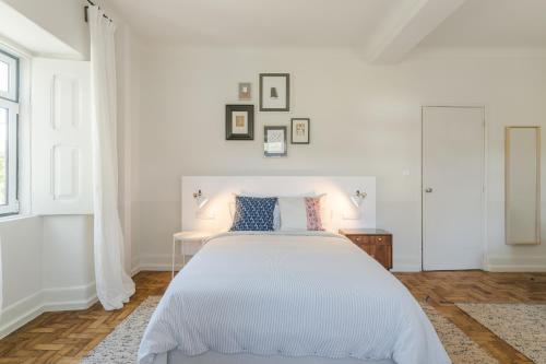 a white bedroom with a bed and a window at Casa Fundeira - Quinta dos Esconhais in Castanheira de Pêra