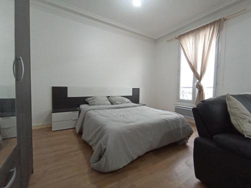 ein weißes Schlafzimmer mit einem Bett und einem Sofa in der Unterkunft Beautiful appartement, 20 min to Champs-Elysées in Maisons-Laffitte