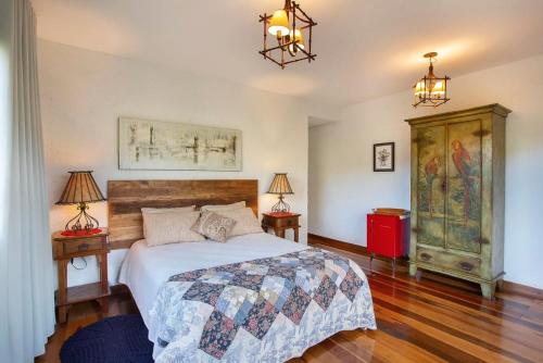 a bedroom with a large bed and two lamps at Sitio Jatoba/Lapinha da Serra in Santana do Riacho