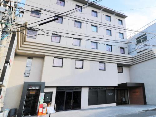 a large white building with lots of windows at Odawara Terminal Hotel in Odawara