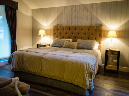 a bedroom with a large bed with two lamps at Pomegranate Guest House in Healesville