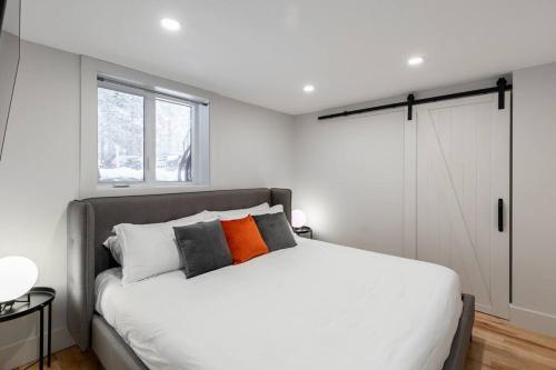 a bedroom with a large white bed and a window at Complexe LIVTremblant by Gestion ELITE - LIV3 in Mont-Tremblant