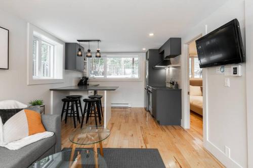 a kitchen and living room with a couch and a table at Complexe LIVTremblant by Gestion ELITE - LIV3 in Mont-Tremblant