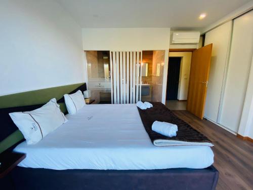 a bedroom with a large bed with white pillows at Dobau casas in Vieira do Minho