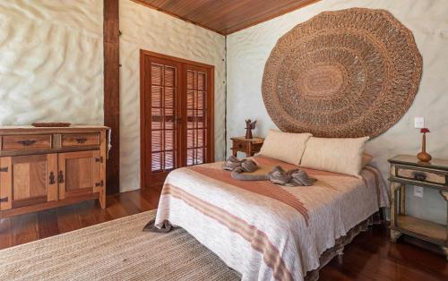 a bedroom with a bed with a large wooden headboard at Sitio Jatoba/Lapinha da Serra in Santana do Riacho