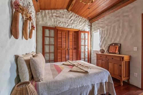 a bedroom with a bed and a wooden ceiling at Sitio Jatoba/Lapinha da Serra in Santana do Riacho