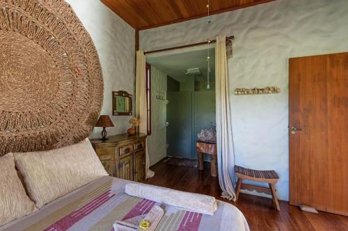a bedroom with a large bed with a wooden headboard at Sitio Jatoba/Lapinha da Serra in Santana do Riacho