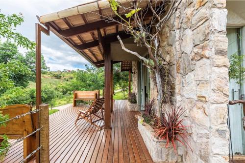 a wooden deck with a stone wall at Sitio Jatoba/Lapinha da Serra in Santana do Riacho