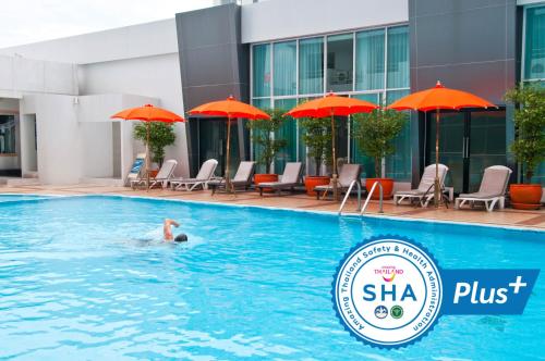 una persona nadando en una piscina en un hotel en Avana Hotel and Convention Centre SHA Extra Plus en Bangkok
