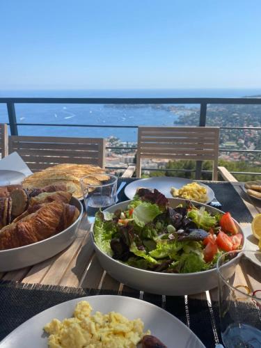 una mesa cubierta con platos de comida y una ensalada en Villa Vista Mare by iVillamia com, en Villefranche-sur-Mer